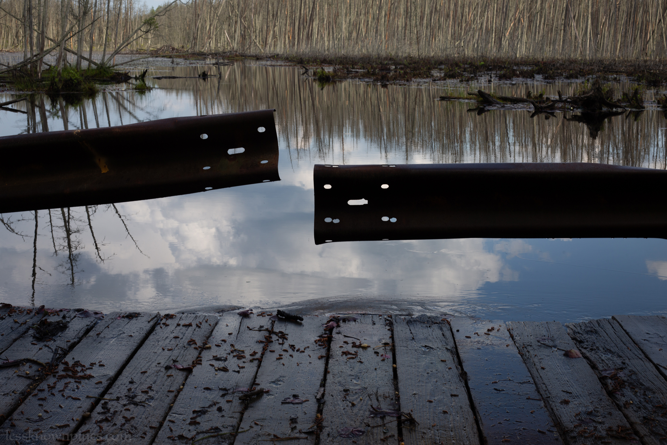 Pond overflows through wooden bridge